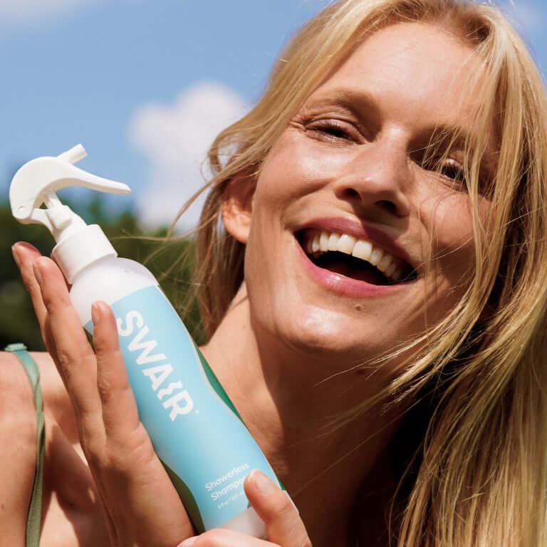 Image of woman holding Showerles Shampoo bottle